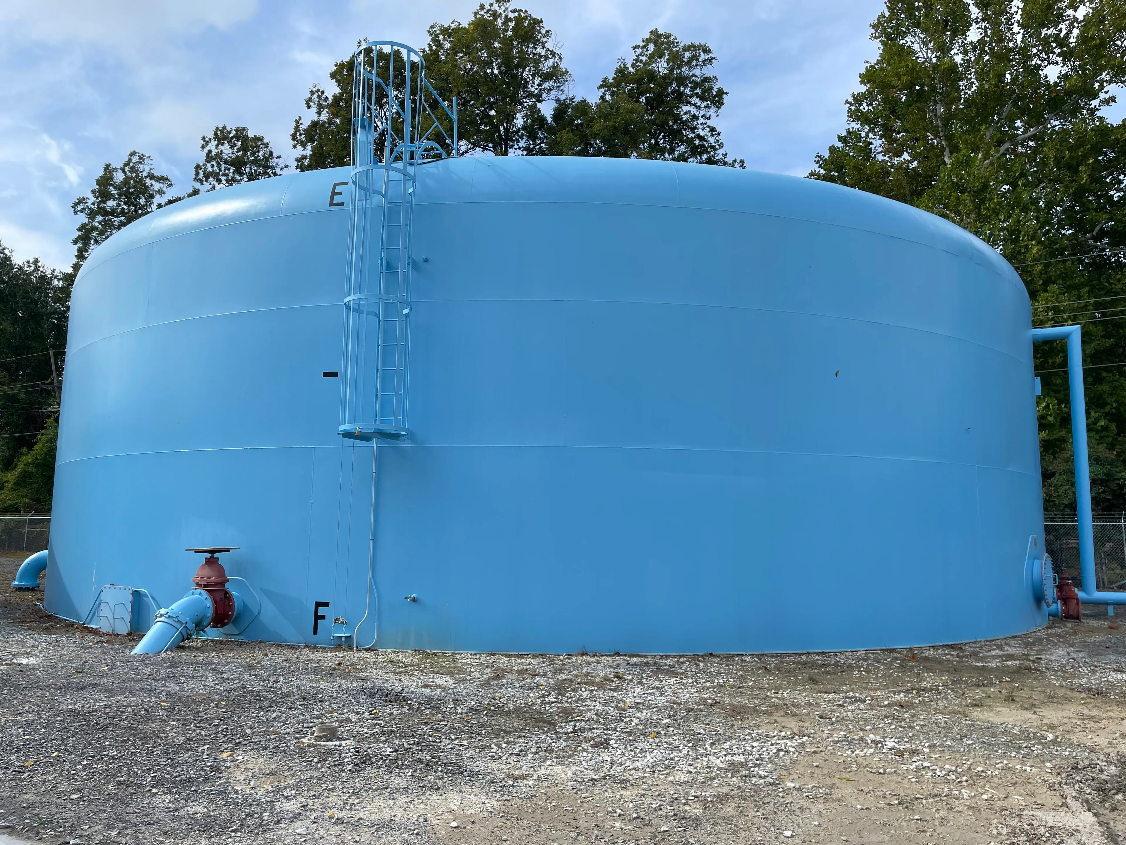 A large blue steel water storage tank at a water treatment plant