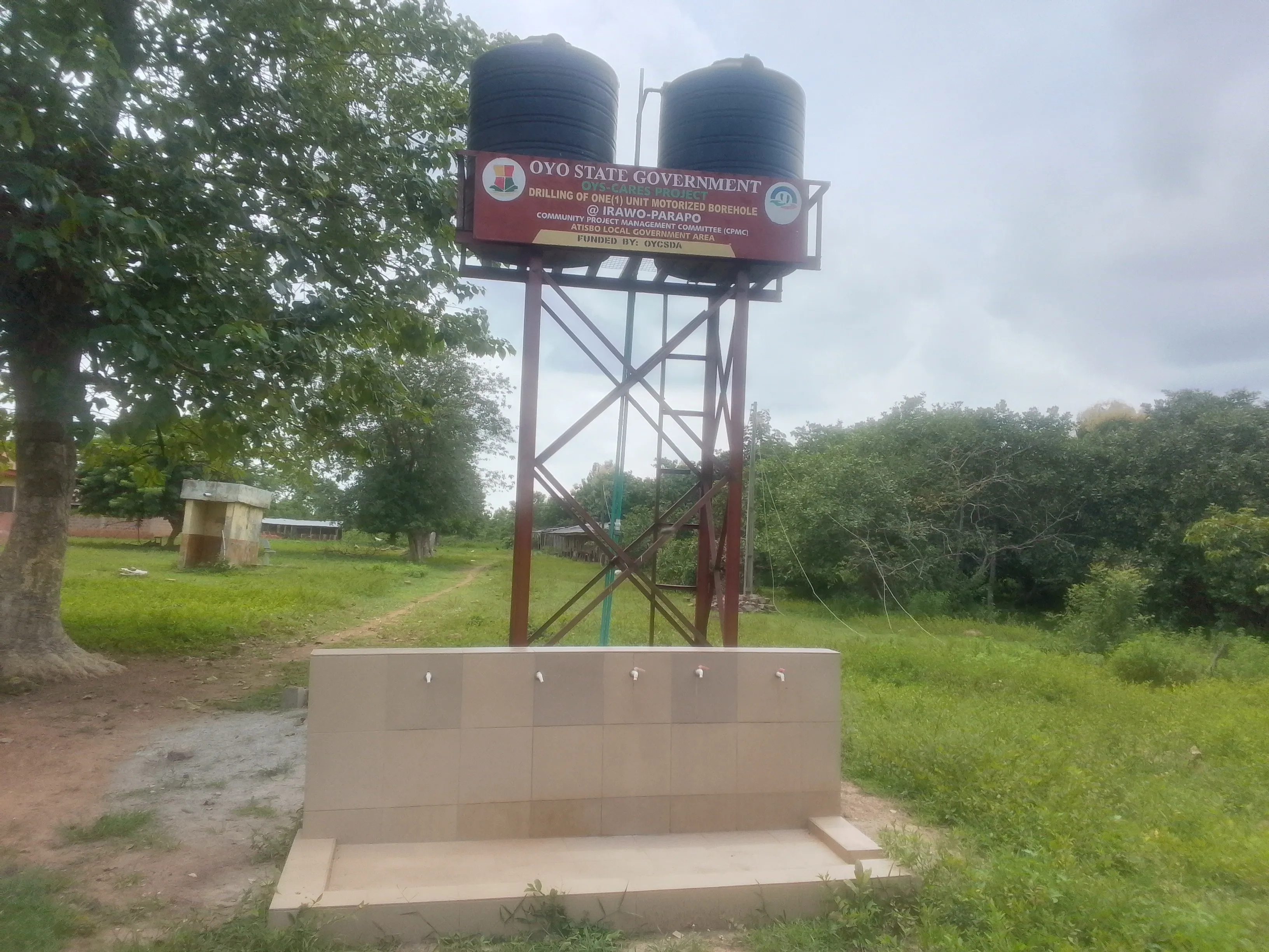 A borehole water supply with an elevated storage tank beside a footpath in Oyo State, Nigeria
